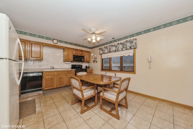 tiled dining area with ceiling fan and sink