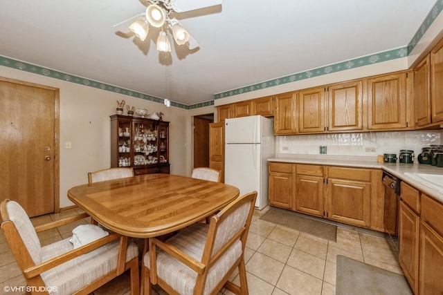 kitchen featuring black dishwasher, light tile patterned floors, white refrigerator, and backsplash