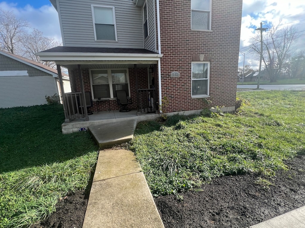 entrance to property with a lawn