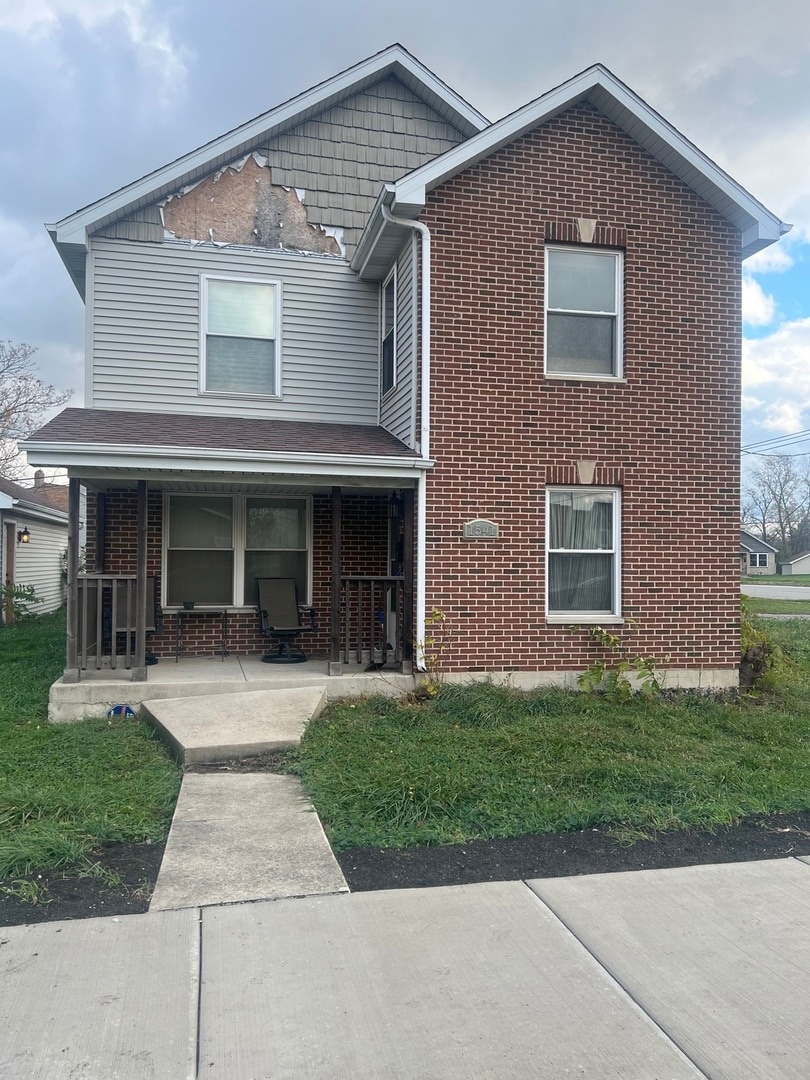 front of property with a porch and a front yard