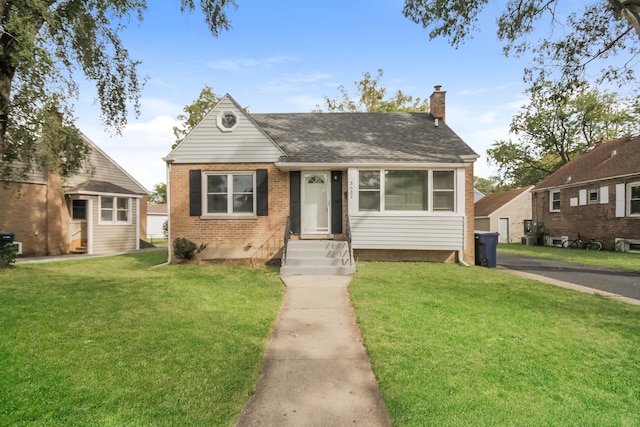 bungalow featuring a shingled roof, brick siding, a chimney, and a front lawn