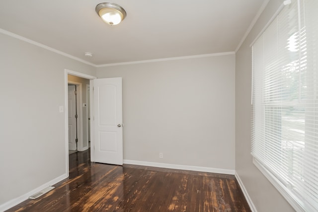 unfurnished room with ornamental molding and dark wood-type flooring