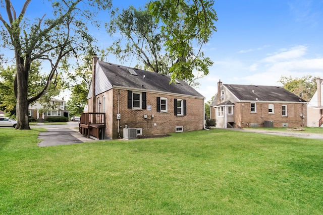 back of house featuring cooling unit and a lawn