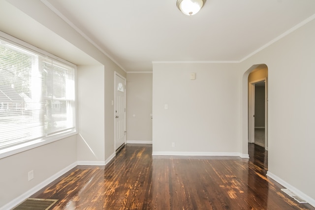 empty room with dark hardwood / wood-style floors and crown molding