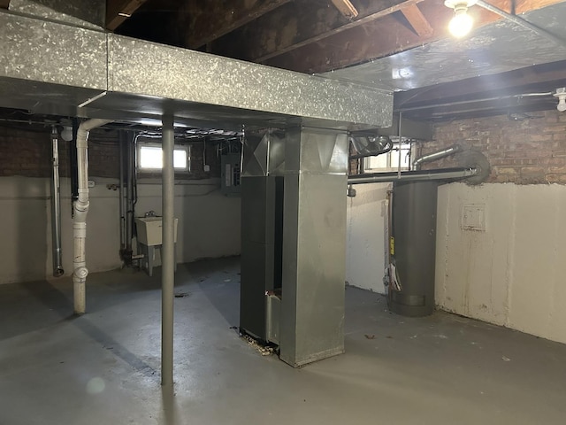 basement featuring heating unit, electric panel, and a sink