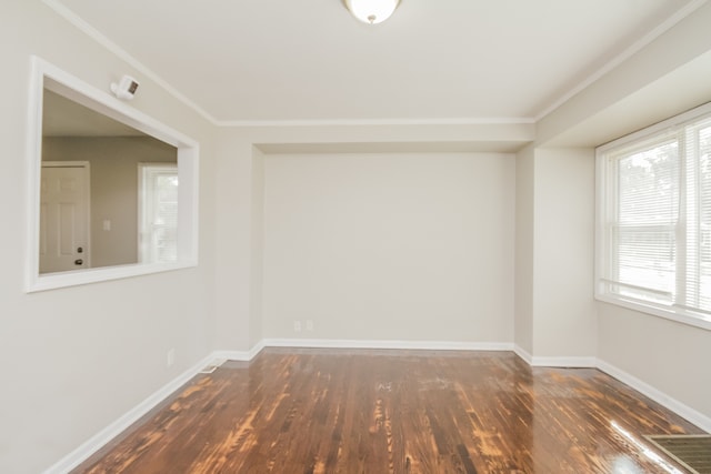 empty room with dark hardwood / wood-style flooring and ornamental molding