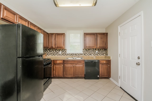 kitchen with light tile patterned floors, sink, backsplash, and black appliances