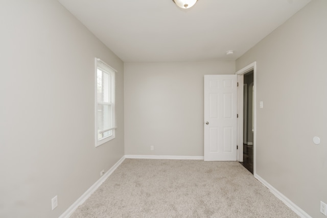 spare room featuring light colored carpet