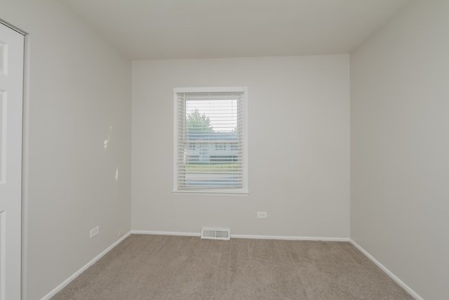 spare room featuring light colored carpet