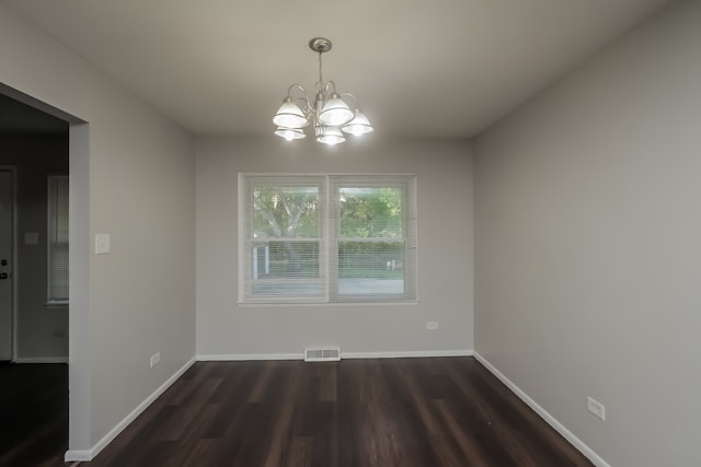 unfurnished dining area with dark hardwood / wood-style flooring and an inviting chandelier