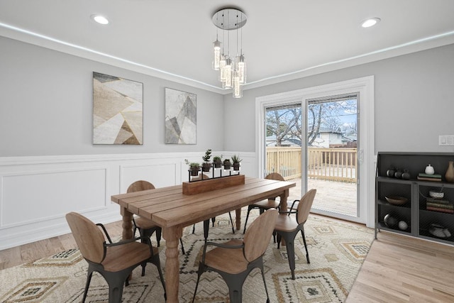 dining space with light wood-type flooring and an inviting chandelier