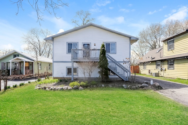 rear view of property with central AC and a yard