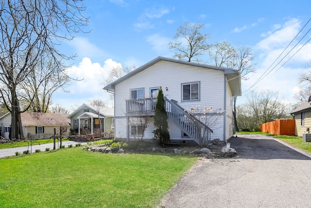 view of front of home with central AC and a front lawn