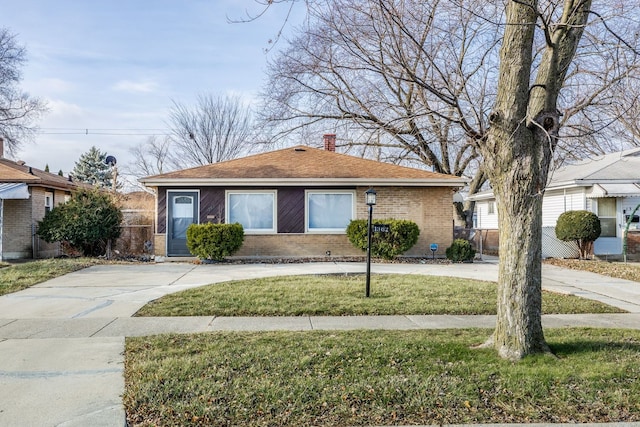 view of front of property with a chimney, fence, a front lawn, and brick siding