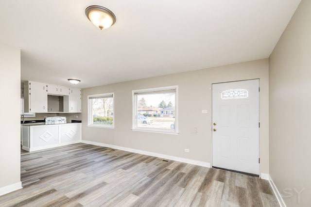 entrance foyer featuring light wood-style flooring and baseboards