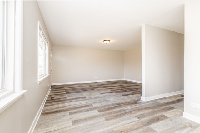 spare room featuring light wood finished floors and baseboards