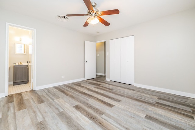 unfurnished bedroom with light wood finished floors, a closet, visible vents, and baseboards