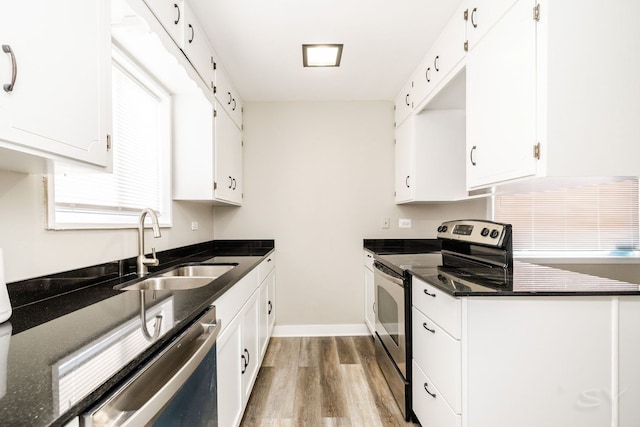 kitchen with light wood-style flooring, appliances with stainless steel finishes, white cabinets, and a sink