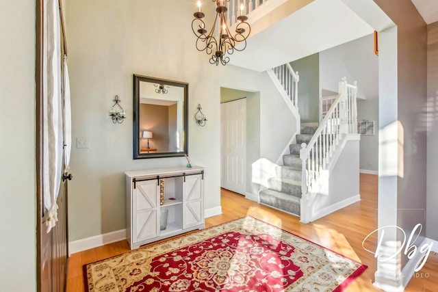 foyer entrance with wood-type flooring and a notable chandelier