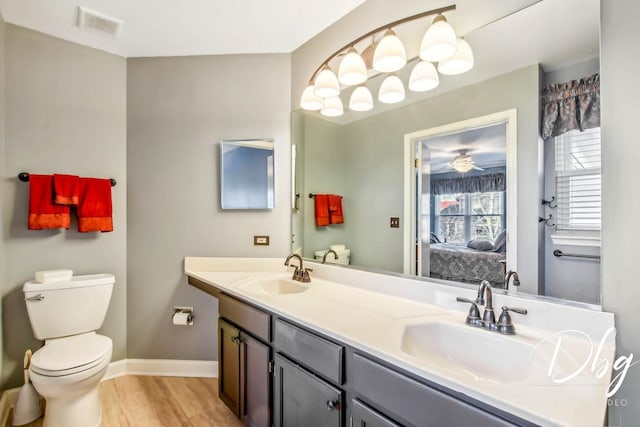 bathroom with wood-type flooring, vanity, and toilet