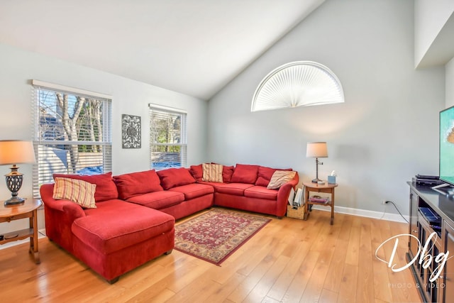 living room with hardwood / wood-style floors and high vaulted ceiling