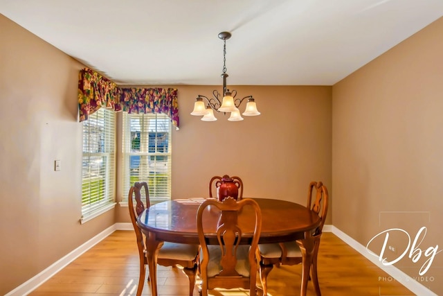 dining room with wood-type flooring and an inviting chandelier