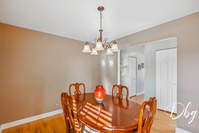 dining space featuring hardwood / wood-style floors and an inviting chandelier