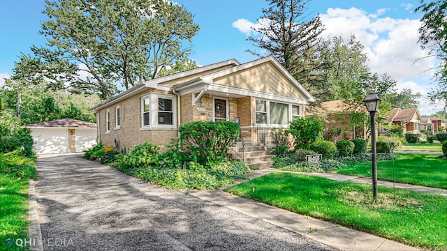 view of front of house with a garage, an outbuilding, and a front lawn