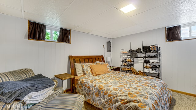 bedroom with wood walls, carpet floors, electric panel, and multiple windows