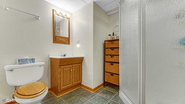 bathroom with tile patterned flooring, vanity, toilet, and a shower with shower door