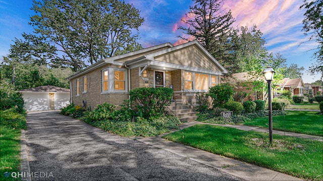 view of front of property featuring a lawn, an outdoor structure, and a garage