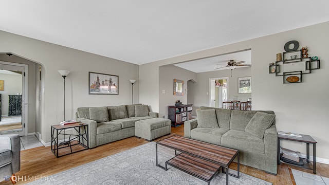 living room with ceiling fan and light hardwood / wood-style flooring