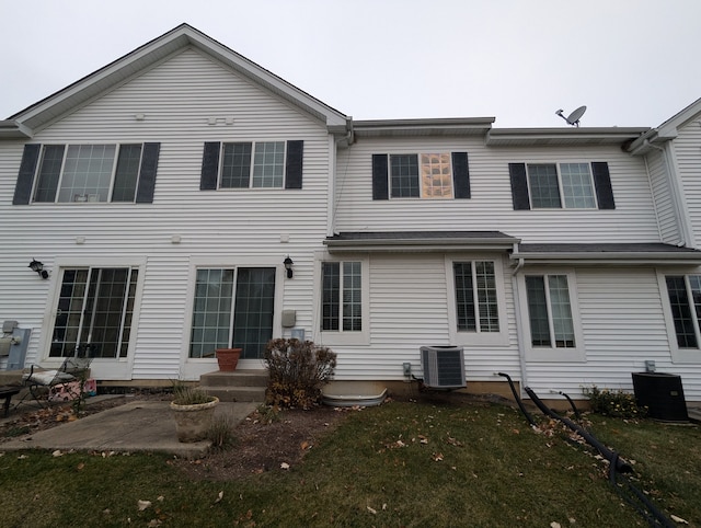 rear view of house featuring a yard, a patio, and central AC unit