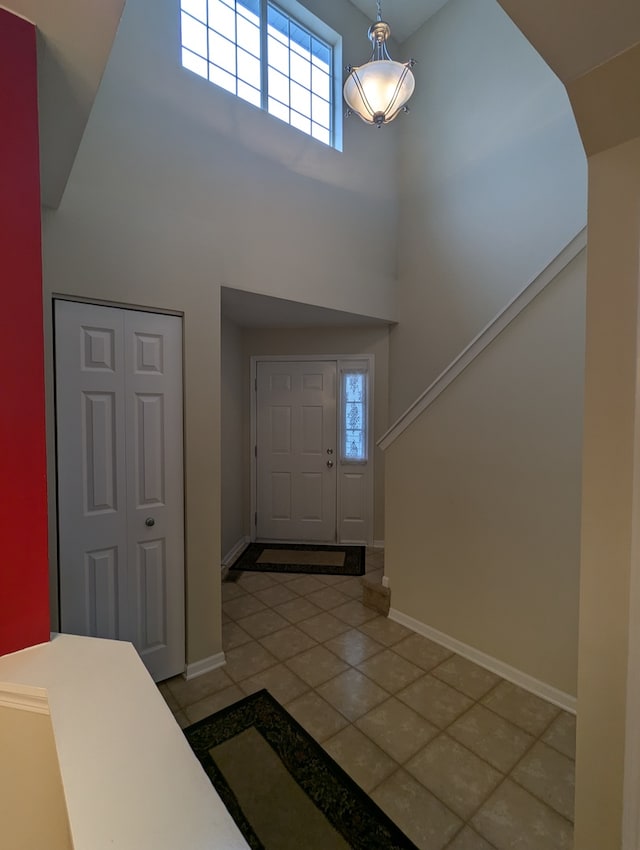 tiled foyer featuring a high ceiling