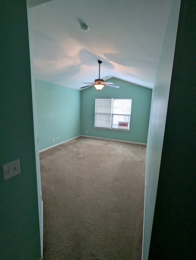 spare room featuring ceiling fan, carpet, and vaulted ceiling