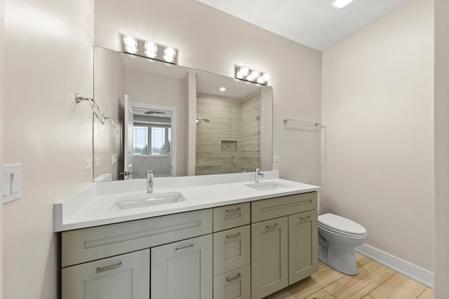 bathroom featuring hardwood / wood-style floors, vanity, toilet, and a shower with shower door