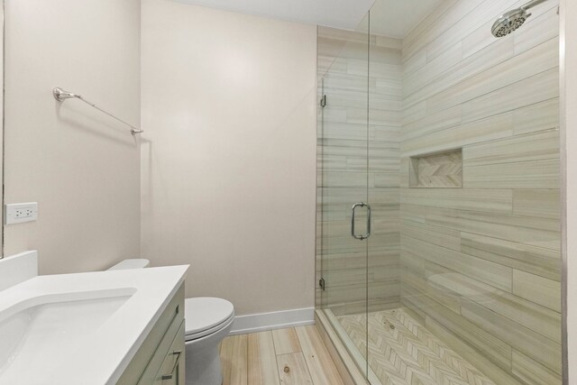 bathroom with walk in shower, vanity, wood-type flooring, and toilet