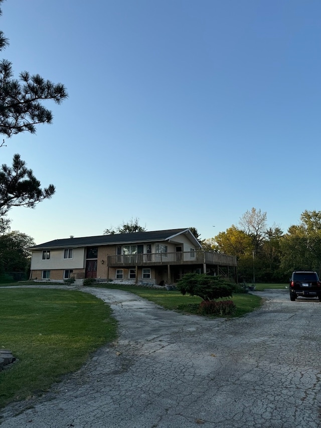 view of front of property featuring a balcony and a front lawn