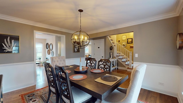 dining space with hardwood / wood-style floors, crown molding, a notable chandelier, and a healthy amount of sunlight