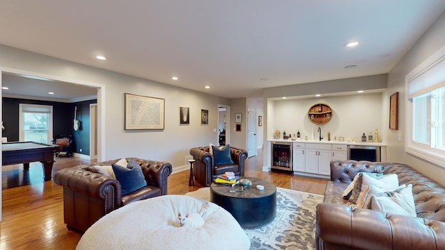 living room with wine cooler, pool table, wet bar, and light wood-type flooring