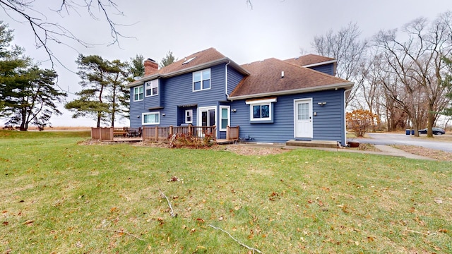 back of property with a wooden deck and a lawn