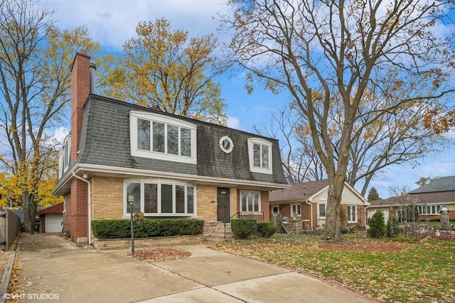 view of front facade featuring a front yard, a garage, and an outdoor structure