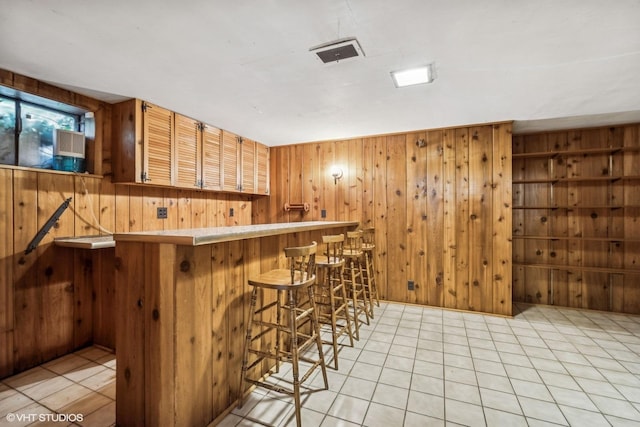 bar with light tile patterned flooring and wooden walls