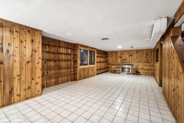 interior space with light tile patterned floors and wooden walls