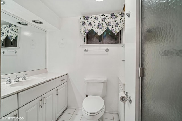 bathroom featuring tile patterned flooring, vanity, toilet, and a shower with shower door