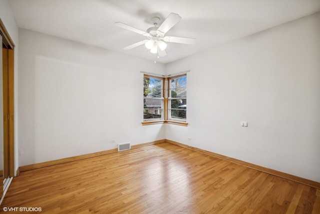 empty room with ceiling fan and light hardwood / wood-style flooring