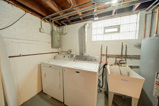 washroom with washer and dryer, electric panel, gas water heater, and sink