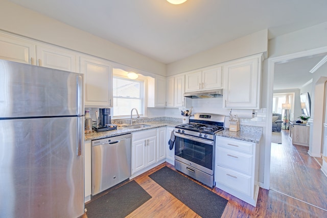 kitchen with backsplash, sink, dark hardwood / wood-style flooring, white cabinetry, and stainless steel appliances