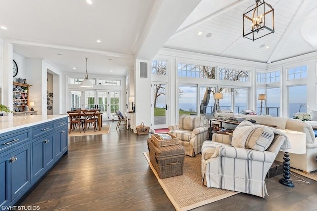 living room with dark hardwood / wood-style floors, wood ceiling, a high ceiling, and a chandelier