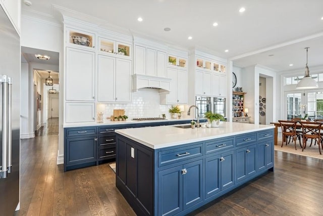 kitchen with blue cabinets, sink, and white cabinetry